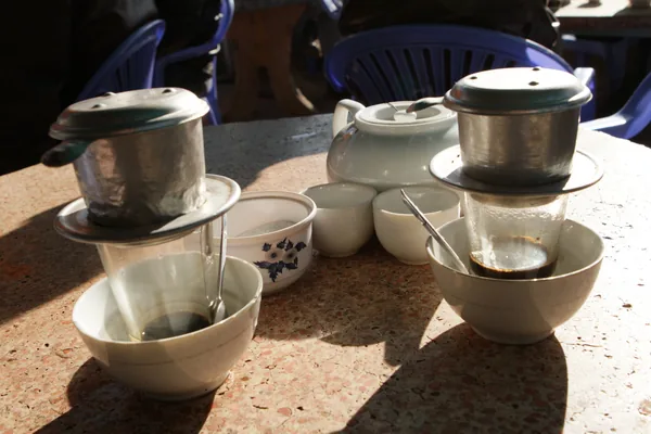 Hai phin cà phê nhỏ giọt trên bàn đá ở Đà Lạt